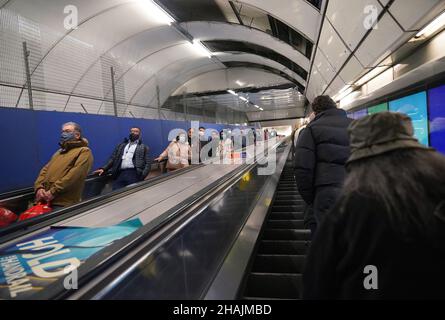 Pendolari su una scala mobile alla stazione della metropolitana Bank alle 18:04 nell'ora di punta della sera, dove sono state introdotte nuove restrizioni per rallentare la diffusione della variante Omicron del coronavirus. Data foto: Lunedì 13 dicembre 2021. Foto Stock