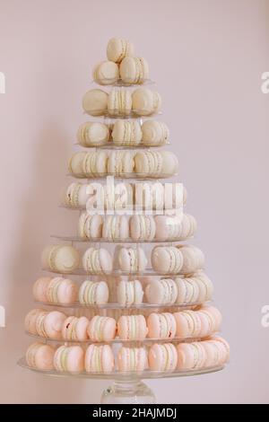 Amaretti francesi. Candy bar. Festa di nozze. Dolci per matrimoni. Bella torta di macaron pasticceria multi-Tier stand pieno di macaron pastello. Piramide torre. Foto Stock