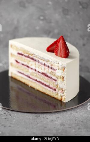 Metà o fetta di deliziosa torta fresca su sfondo bianco. Torta alle fragole. Torta alle fragole con spinaci. Torte verdi con strato di fragola e crema Foto Stock