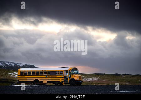 Sólheimajökull, Islanda, con una drammatica illuminazione di giorno con neve e ghiaccio intorno e l'iconico ghiacciaio e bus del ghiacciaio Foto Stock