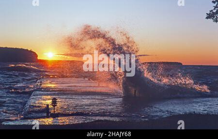 Arrabbiato Lake Michigan onde si scontrano contro un molo al tramonto a Ephraim, Wisconsin, sulla penisola di Door County. Foto Stock