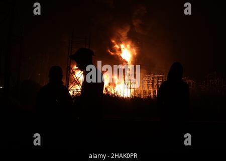 Kolkata, Bangal occidentale, India. 13th Dic 2021. I vigili del fuoco detengono un tubo di sospensione per adularsi le fiamme mentre scoppiò un incendio massiccio al Power House e vicino a una fabbrica di cera ad Howrah, nel Bengala Occidentale. (Credit Image: © Dipa Chakraborty/Pacific Press via ZUMA Press Wire) Credit: ZUMA Press, Inc./Alamy Live News Foto Stock