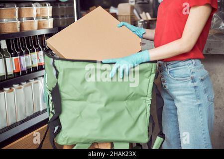 Consegna donna imballaggio scatole di cibo al chiuso Foto Stock