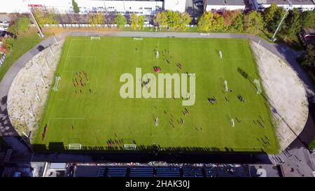 Giocatori di calcio che corrono intorno al campo di calcio. Vista dall'alto del torneo calcistico giovanile. Foto Stock