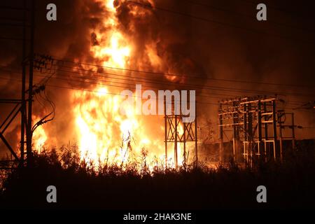 Kolkata, Bangal occidentale, India. 13th Dic 2021. I vigili del fuoco detengono un tubo di sospensione per adularsi le fiamme mentre scoppiò un incendio massiccio al Power House e vicino a una fabbrica di cera ad Howrah, nel Bengala Occidentale. (Credit Image: © Dipa Chakraborty/Pacific Press via ZUMA Press Wire) Credit: ZUMA Press, Inc./Alamy Live News Foto Stock