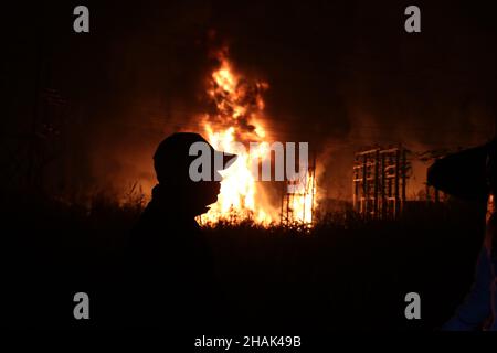 Kolkata, Bangal occidentale, India. 13th Dic 2021. I vigili del fuoco detengono un tubo di sospensione per adularsi le fiamme mentre scoppiò un incendio massiccio al Power House e vicino a una fabbrica di cera ad Howrah, nel Bengala Occidentale. (Credit Image: © Dipa Chakraborty/Pacific Press via ZUMA Press Wire) Credit: ZUMA Press, Inc./Alamy Live News Foto Stock