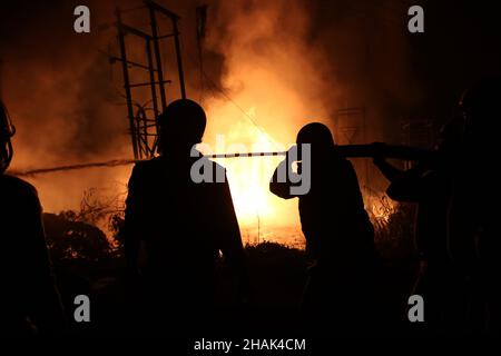 Kolkata, Bangal occidentale, India. 13th Dic 2021. I vigili del fuoco detengono un tubo di sospensione per adularsi le fiamme mentre scoppiò un incendio massiccio al Power House e vicino a una fabbrica di cera ad Howrah, nel Bengala Occidentale. (Credit Image: © Dipa Chakraborty/Pacific Press via ZUMA Press Wire) Credit: ZUMA Press, Inc./Alamy Live News Foto Stock