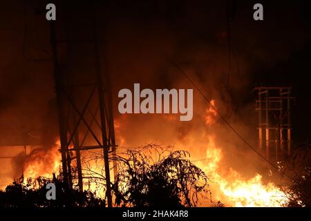 Kolkata, Bangal occidentale, India. 13th Dic 2021. I vigili del fuoco detengono un tubo di sospensione per adularsi le fiamme mentre scoppiò un incendio massiccio al Power House e vicino a una fabbrica di cera ad Howrah, nel Bengala Occidentale. (Credit Image: © Dipa Chakraborty/Pacific Press via ZUMA Press Wire) Credit: ZUMA Press, Inc./Alamy Live News Foto Stock