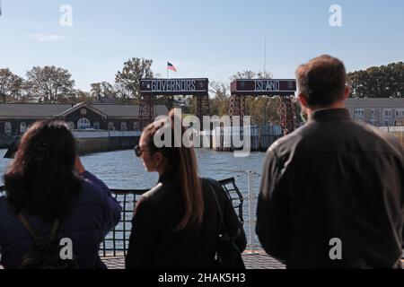 I passeggeri del traghetto per Governors Island di New York aspettano che la barca attracchi in modo che possano imbarcarsi. Foto Stock