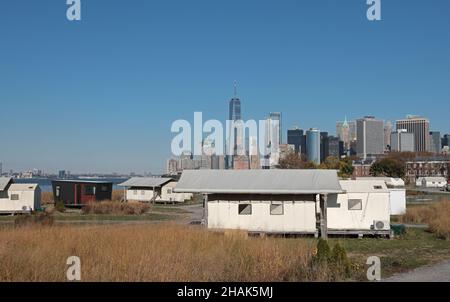 Vista delle cabine glamping sulla Governors Island di New York dei grattacieli con i grattacieli del centro di Manhattan sullo sfondo. Foto Stock