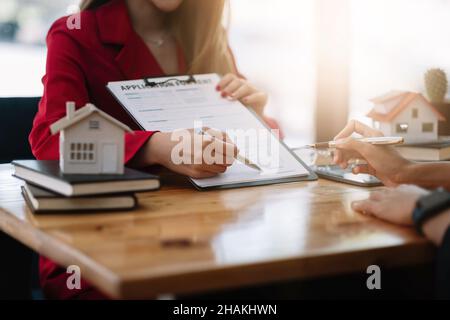Il cliente firma i documenti per fare il contratto legalmente, vendita della casa e concetto di immobile di affitto della casa Foto Stock