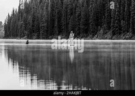 7/14/21 - Crested Butte, Colorado - una donna dimostra come fare i cavalletti e lo yoga su una tavola da pagaia. Foto Stock