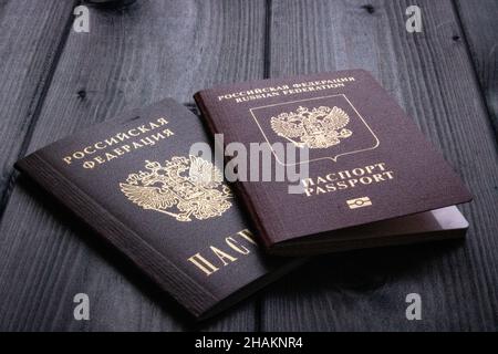 Due passaporti della Federazione Russa si trovano su una superficie di legno ruvida. Foto d'epoca. Concetto di viaggio. Foto Stock