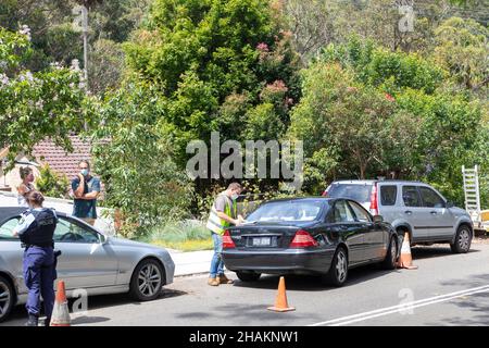 Il poliziotto di Sydney assiste alla scena di una collisione con l'auto ad Avalon Beach Sydney, a causa della convivid 19 persone indossano maschere facciali, Sydney, Australia Foto Stock