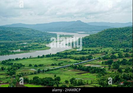 Ferrovia di Konkan che passa attraverso risaie campo Foto Stock