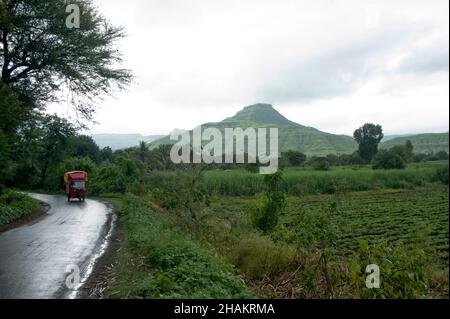 Vista di un Pandavgarh (Forte) e terreno agricolo in pioggia Foto Stock