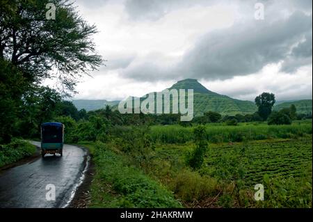 Vista di un Pandavgarh (Forte) e terreno agricolo in pioggia Foto Stock