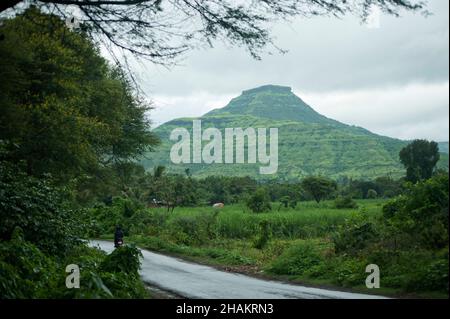 Vista di un Pandavgarh (Forte) e terreno agricolo in pioggia Foto Stock