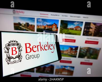 Smartphone con logo della società britannica The Berkeley Group Holdings plc sullo schermo di fronte al sito web. Messa a fuoco al centro-sinistra del display del telefono. Foto Stock