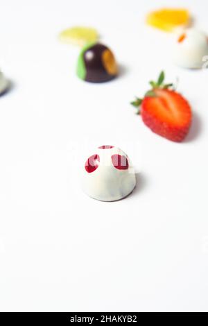 Colorati bonbon al cioccolato messicano con frutta su sfondo bianco Foto Stock