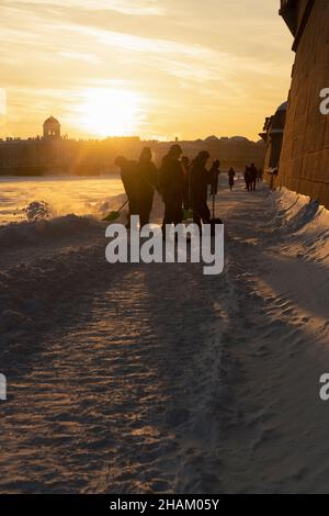 San Pietroburgo, Russia - 22 febbraio 2021: Sagome di cadetti che schiarendo la neve e illuminati dal bel sole della sera Foto Stock