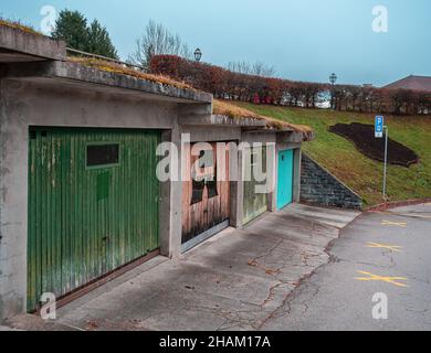 Gruyeres, Svizzera - 23 novembre 2021: Costruzione di garage generici con porte di garage in diversi colori Foto Stock