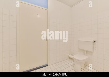 Bagno con pavimenti piastrellati di bianco e pareti bianche Foto Stock