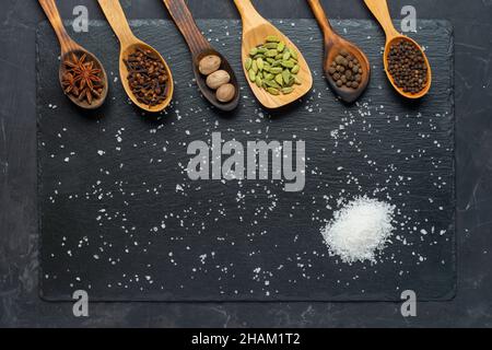 Selezione di spezie su tavola di legno scuro. Cibo o concetto di cottura speziato, mangiare sano sfondo. Foto Stock