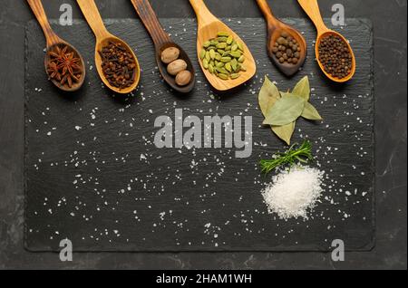 Selezione di spezie su tavola di legno scuro. Cibo o concetto di cottura speziato, mangiare sano sfondo. Foto Stock
