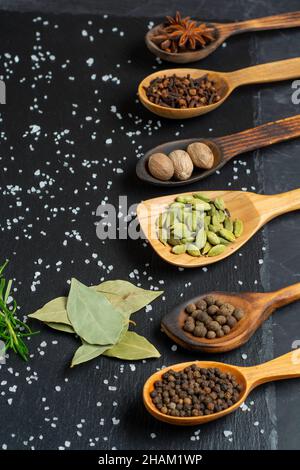 Selezione di spezie su tavola di legno scuro. Cibo o concetto di cottura speziato, mangiare sano sfondo. Foto Stock