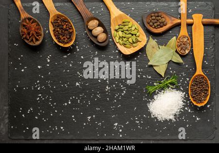Selezione di spezie su tavola di legno scuro. Cibo o concetto di cottura speziato, mangiare sano sfondo. Foto Stock
