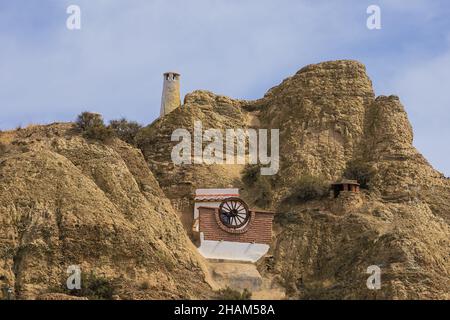 Balcone di un troglodita habitat contro una collina in Guadix Foto Stock