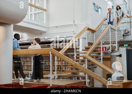 Studenti su scale in biblioteca Foto Stock