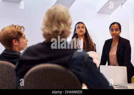 Uomini d'affari che discutono dell'assistente vocale del robot durante la riunione Foto Stock