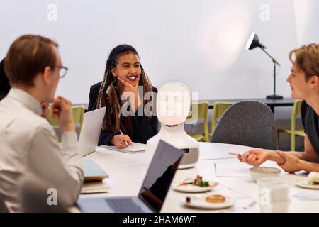 Uomini d'affari che discutono dell'assistente vocale del robot durante la riunione Foto Stock