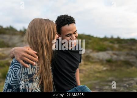 Sorridente giovane coppia abbracciante nella natura Foto Stock