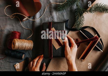 Vista ad angolo alto delle mani del woman che tengono avvolto presente Foto Stock