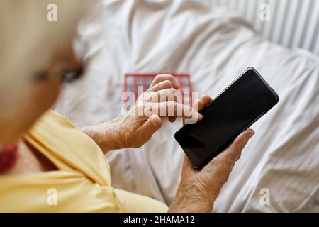 Le mani della donna che tengono il telefono cellulare Foto Stock