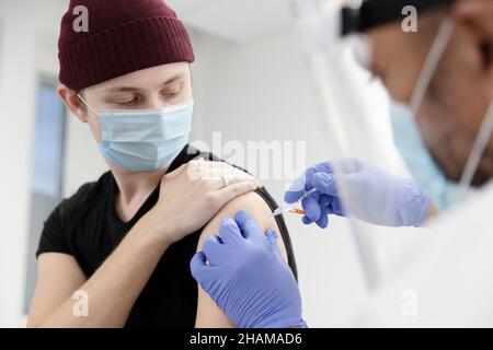 Giovane che viene vaccinato Foto Stock