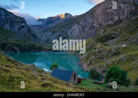 Rifugio di montagna dalla pietra su un lago di montagna nei Pirenei del Lac des Gloriettes - Francia Foto Stock