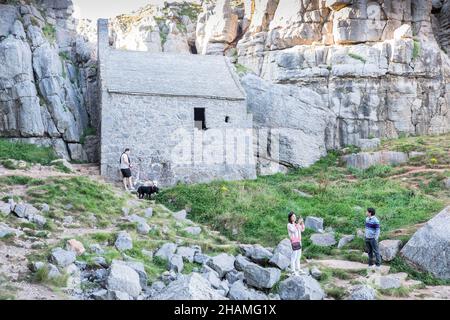 Piccola, antica, cappella, a,St Govans Chapel,Saint Govans,St Govans Head,Tiny,heremits,cell,next,to,Sea,water,Coast,Coast,Coastline,Pembrokeshire,West,Wales,Welsh,GB,Great Britain,British,St Govan's Chapel è una cappella situata a St. Govan's Head, Pembrokeshire nel Galles sud-occidentale. Costruito sul lato di una scogliera calcarea, l'edificio misura 20 x 12 piedi con pareti costruite in pietra calcarea, ed è composto da due camere, una nella parte anteriore e una nella parte posteriore. La maggior parte della cappella è stata costruita nel XIII secolo, anche se alcune parti di essa possono risalire al sesto secolo. Foto Stock