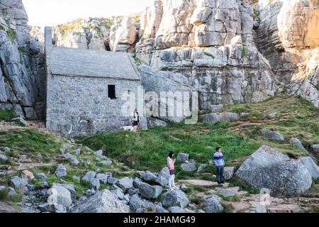 Piccola, antica, cappella, a,St Govans Chapel,Saint Govans,St Govans Head,Tiny,heremits,cell,next,to,Sea,water,Coast,Coast,Coastline,Pembrokeshire,West,Wales,Welsh,GB,Great Britain,British,St Govan's Chapel è una cappella situata a St. Govan's Head, Pembrokeshire nel Galles sud-occidentale. Costruito sul lato di una scogliera calcarea, l'edificio misura 20 x 12 piedi con pareti costruite in pietra calcarea, ed è composto da due camere, una nella parte anteriore e una nella parte posteriore. La maggior parte della cappella è stata costruita nel XIII secolo, anche se alcune parti di essa possono risalire al sesto secolo. Foto Stock