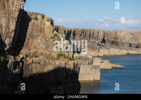 Piccola, antica, cappella, a,St Govans Chapel,Saint Govans,St Govans Head,Tiny,heremits,cell,next,to,Sea,water,Coast,Coast,Coastline,Pembrokeshire,West,Wales,Welsh,GB,Great Britain,British,St Govan's Chapel è una cappella situata a St. Govan's Head, Pembrokeshire nel Galles sud-occidentale. Costruito sul lato di una scogliera calcarea, l'edificio misura 20 x 12 piedi con pareti costruite in pietra calcarea, ed è composto da due camere, una nella parte anteriore e una nella parte posteriore. La maggior parte della cappella è stata costruita nel XIII secolo, anche se alcune parti di essa possono risalire al sesto secolo. Foto Stock