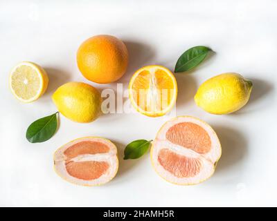 Brillante estate vari citrus e foglie sfondo. Bordo esotico su sfondo bianco. Vista dall'alto. Foto Stock