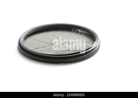 Primo piano scatto studio ad angolo alto di filtro polarizzatore circolare nero con vetro incrinato, isolato su sfondo bianco. Concetto per danni all'ingranaggio fotografico Foto Stock