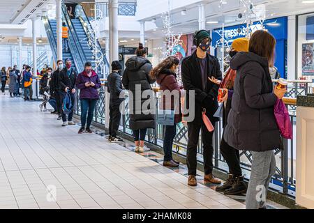 WIMBLEDON LONDRA, REGNO UNITO. 14 dicembre 2021. I membri del pubblico che fanno la fila all'interno del centro commerciale Center Court di Wimbledon per ricevere le loro vaccinazioni Covid-19 e booster jab. Il governo sta accelerando il suo programma di booster Covid-19 a causa delle crescenti preoccupazioni circa il rapido aumento del ceppo variante Omicron e mira a offrire un jab booster per ogni adulto entro la fine dell'anno. Credit: amer Ghazzal/Alamy Live News Foto Stock