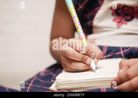 scrittura della mano del bambino sul blocco note Foto Stock