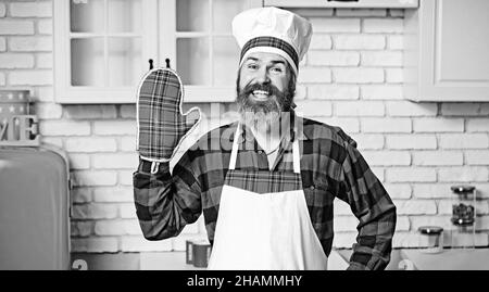 Chef bearded che cucinano piatti gustosi in una cucina in un ristorante. Foto Stock