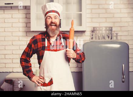 Bel cuoco di guef con becco che prepara gli spaghetti su una cucina. Chef cucina pasto. Foto Stock