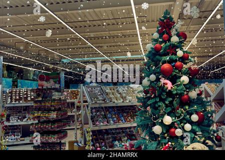 Bellissimo albero di Natale decorato con palla colorata, decorazioni di Capodanno sugli scaffali nel supermercato Epidcenter a Odessa Ucraina Foto Stock